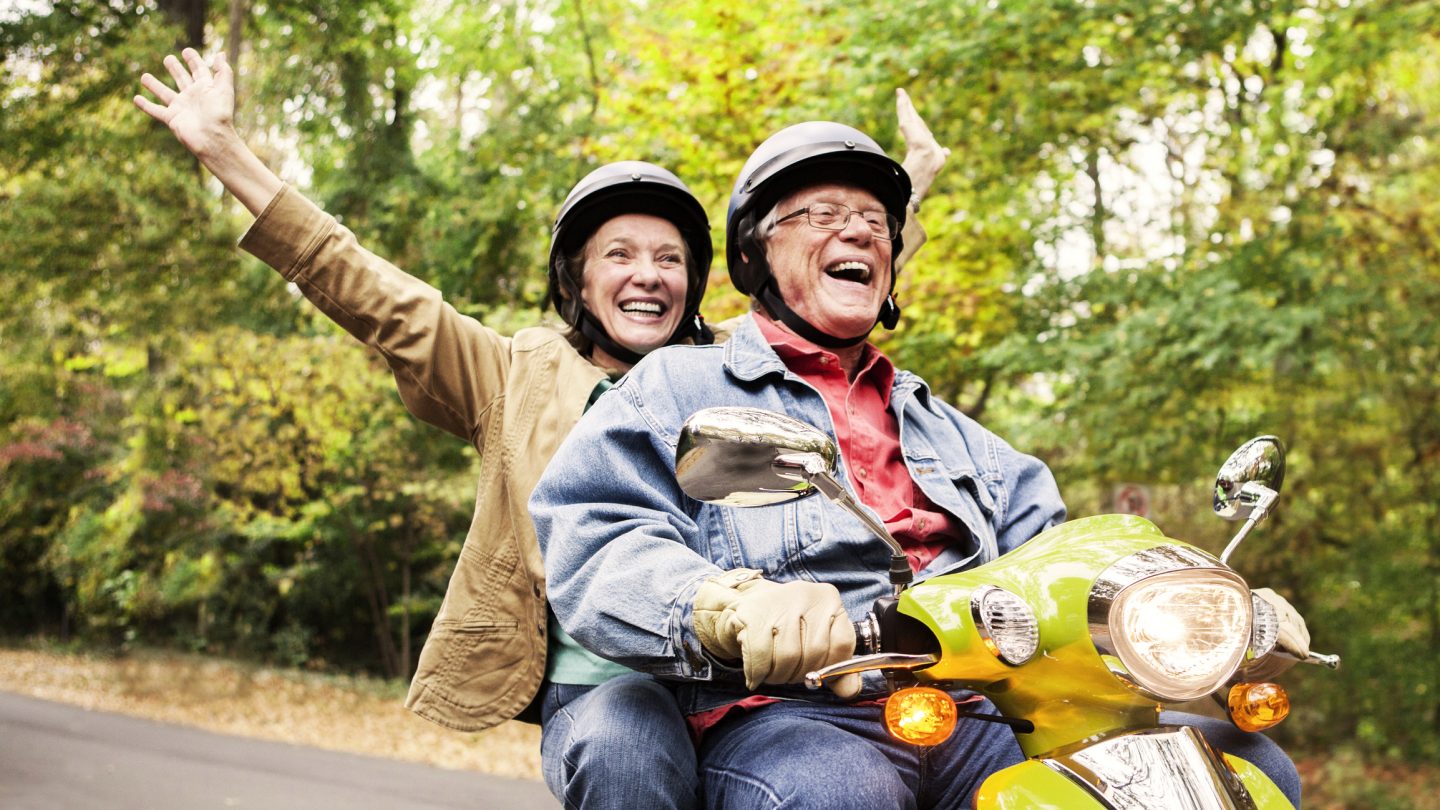 Couple on moped laughing